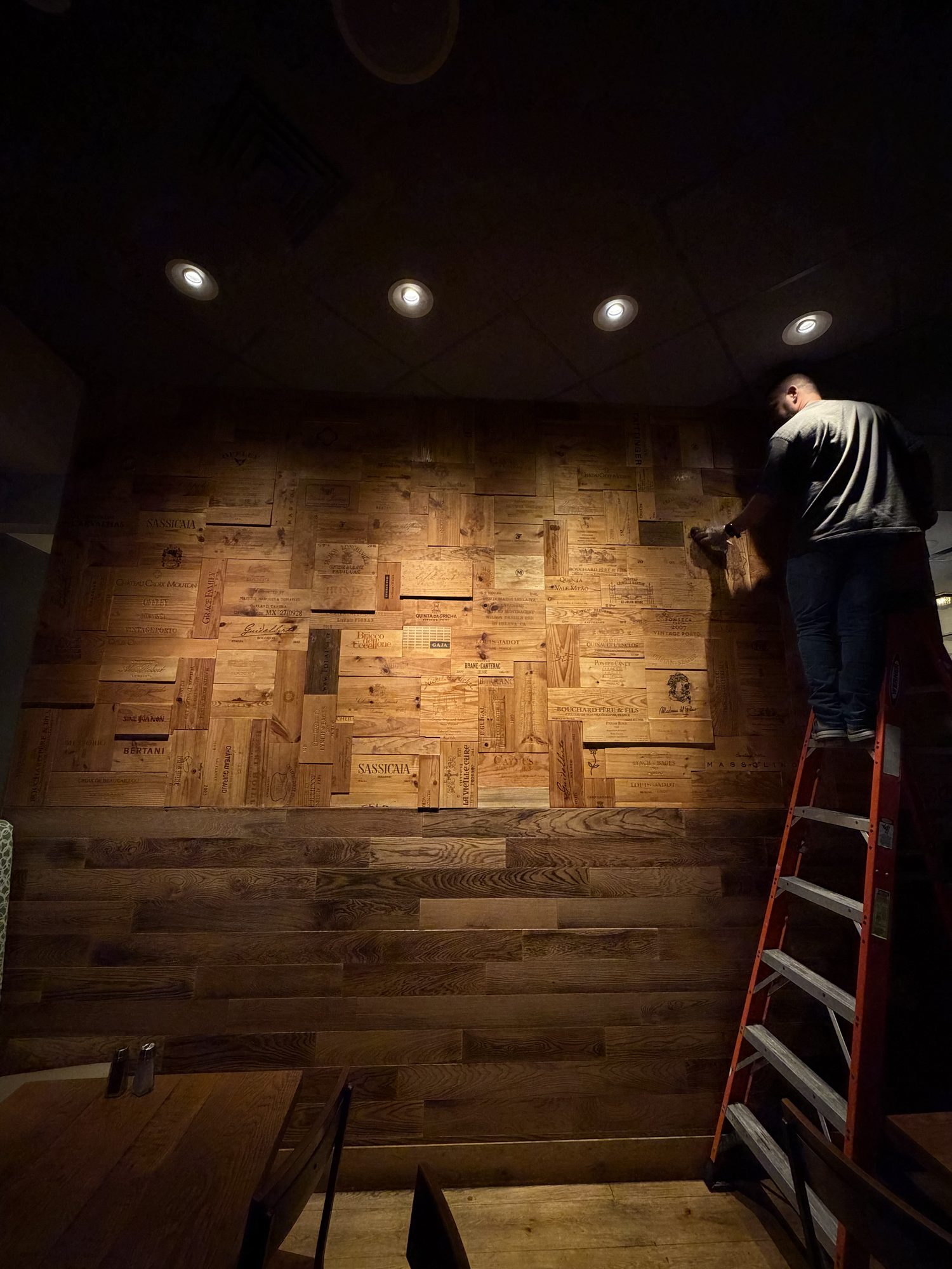Setting reclaimed wine-crate panels on a Tampa restaurant buildout.